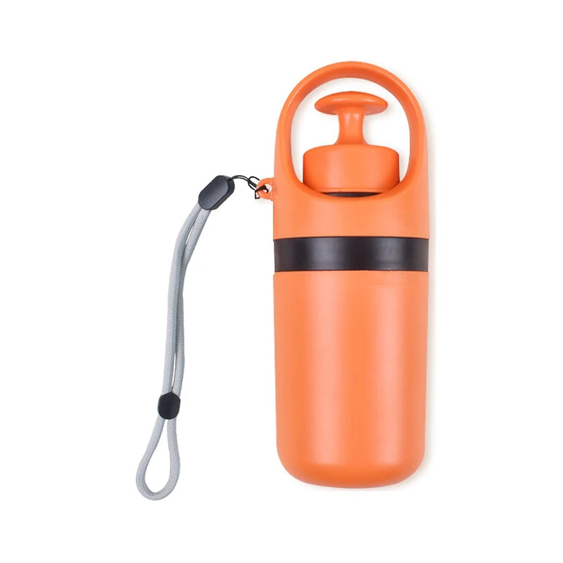 Orange portable dog pooper scooper with a black band and gray strap on a white background